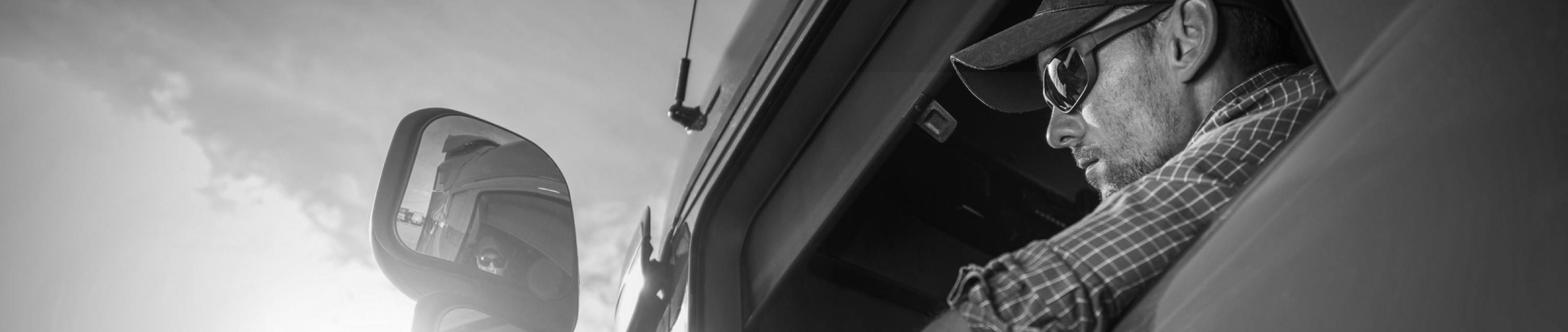 Sears Seating wants those who work hard to work comfortably. Photo of male truck driver looking through side mirror.